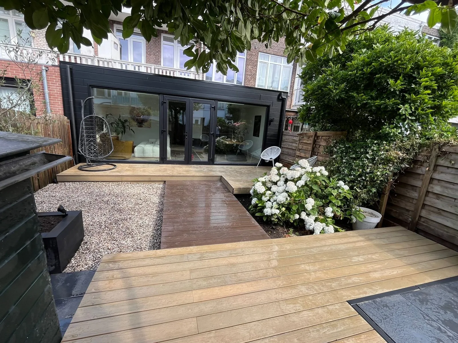 Afgewerkte tuin met houten terras, grind en beplanting