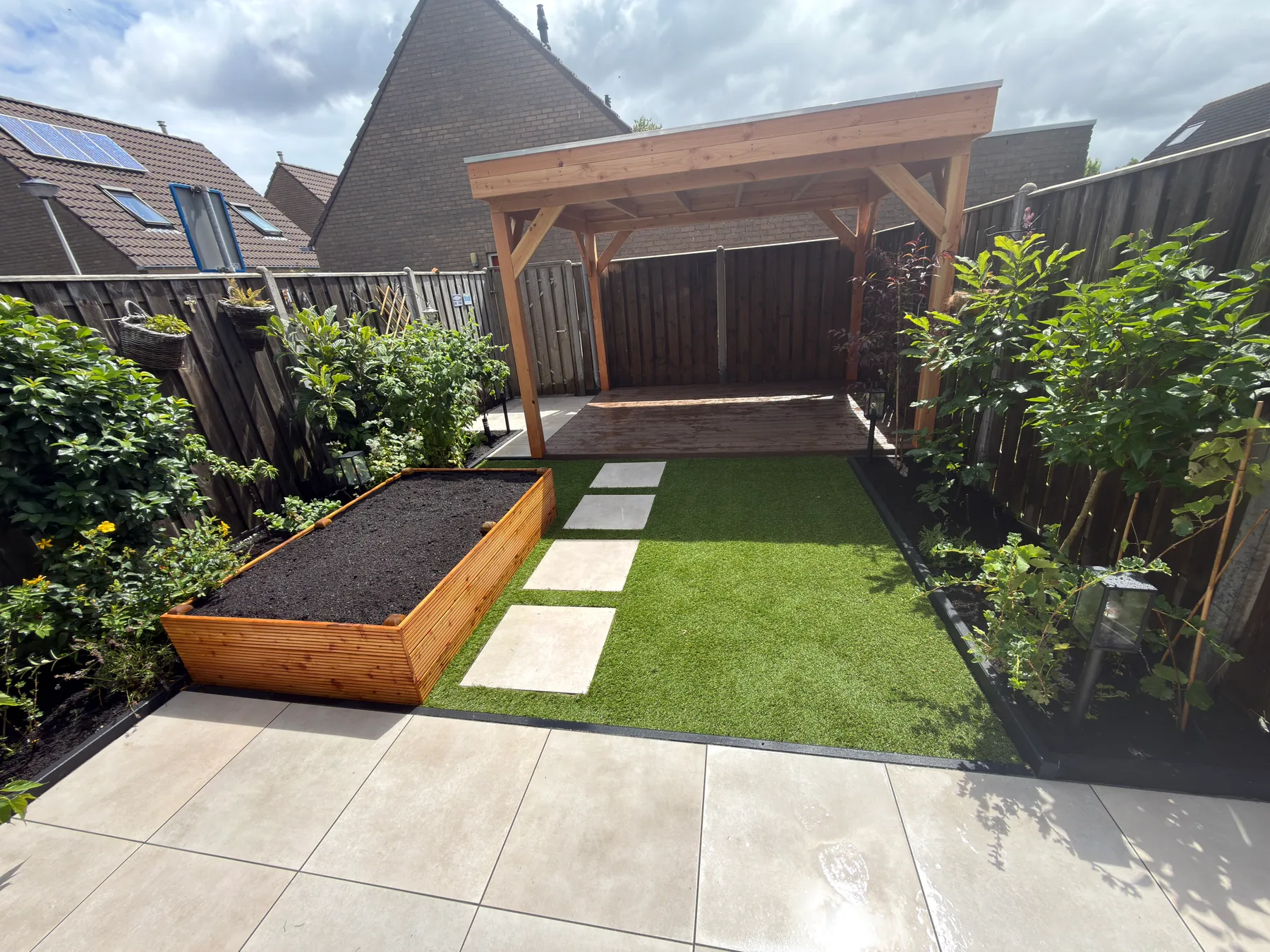 Tuin met houten overkapping, terras en groenwerk