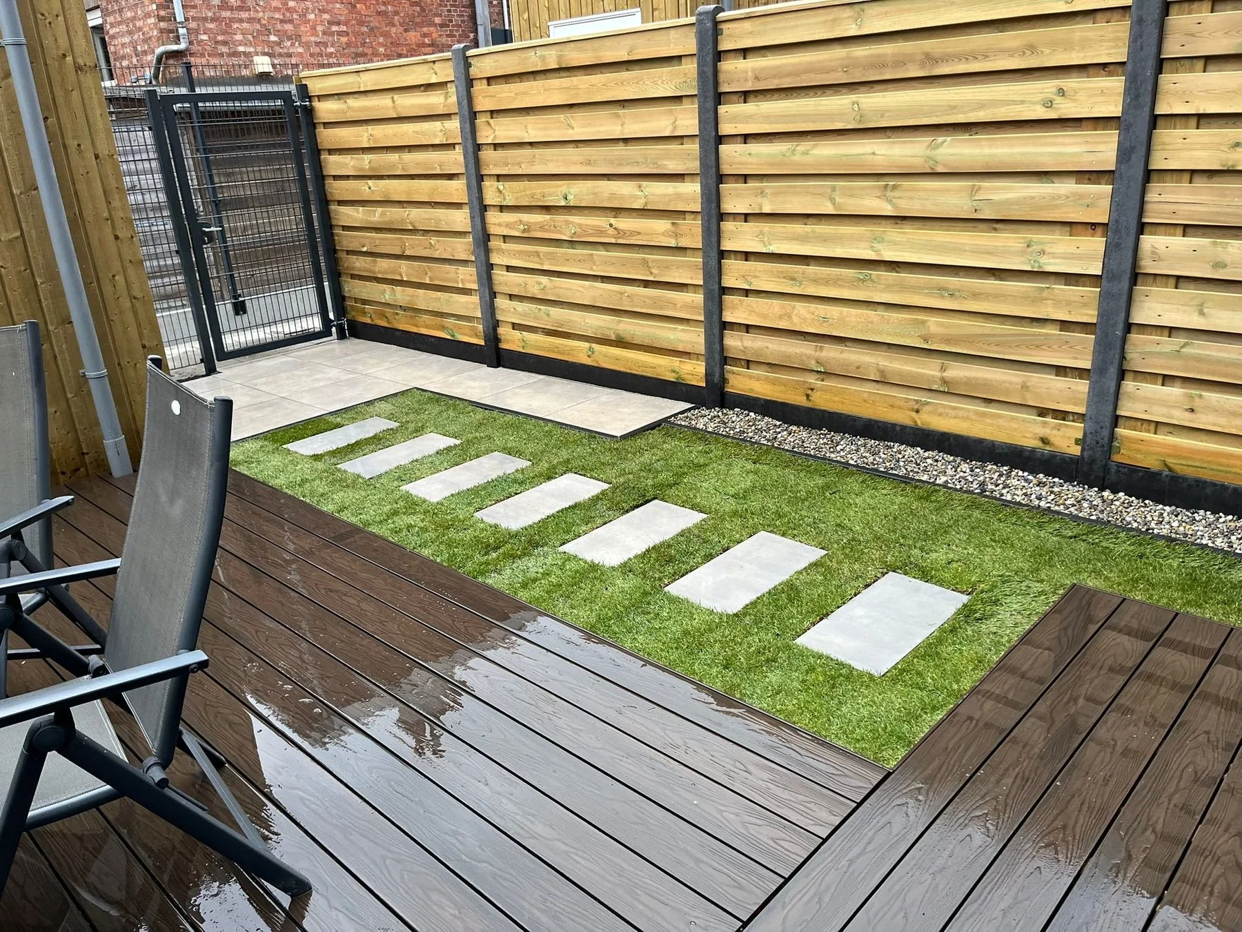 Composiet terras met gazon en nieuwe schutting